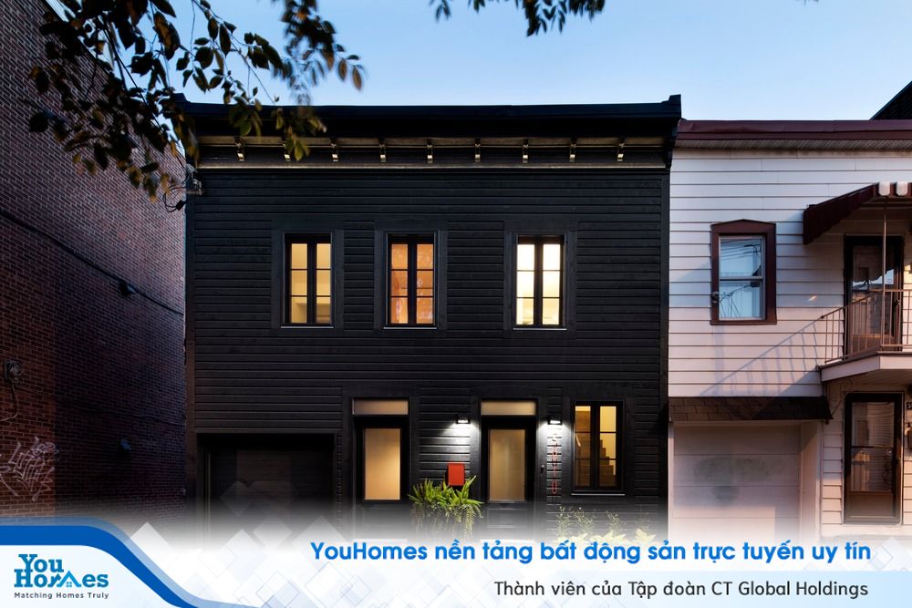 Mặt tiền của ngôi nhà được ốp gỗ đen toàn phần