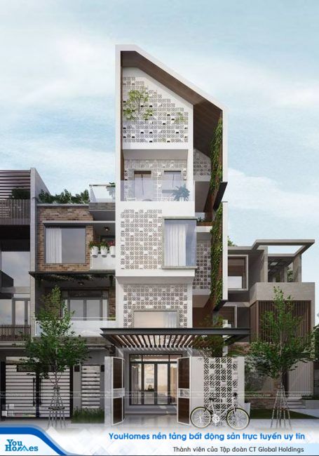 Mẫu nhà ống cùng mái nhọn và mặt tiền được ốp gạch thông gió màu trắng.